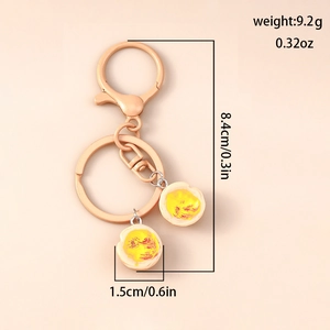 Detail of creative resin fried egg charms on a gold keychain with dimension specifications