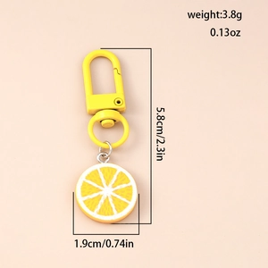 Detail view of yellow lemon slice keychain with metal clip and precise dimensions