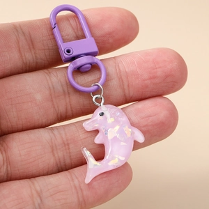 Porte-clés dauphin en résine rose avec paillettes et anneau métallique violet en détail
