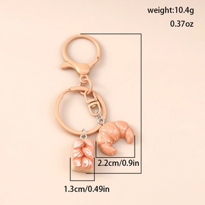 Detailed view of croissant keychain dimensions and weight in rose gold metal finish