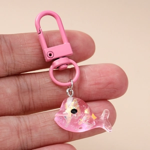 Gros plan détaillé d'un porte-clés dauphin en résine rose avec des paillettes brillantes