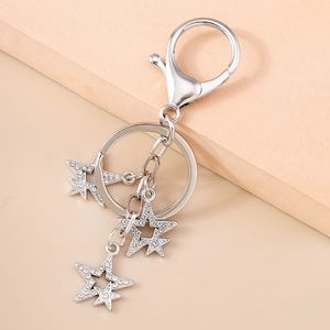 Vue détaillée d'un porte-clés étoile en argent avec cristaux sur fond beige uni