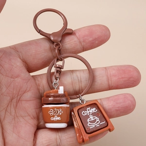 Handheld detail of creative coffee theme keychain with mini cup and signage pendant