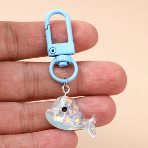 Porte-clés dauphin bleu avec paillettes irisées et finition en résine brillante
