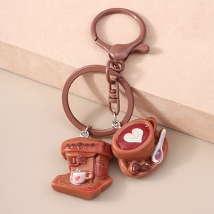 Macro detail of brown coffee machine keychain with latte art charm and matte metal ring