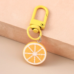 Detailed close-up of a realistic yellow lemon slice keychain with a metal U-shaped clasp