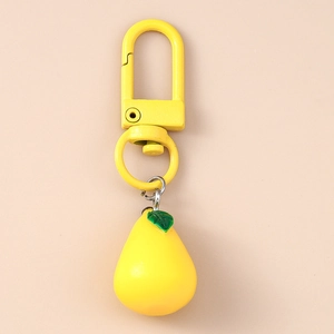 Detailed macro view of yellow pear fruit keychain with matching green leaf and metal carabiner