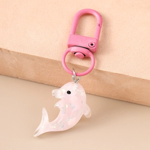 Gros plan du porte-clés dauphin rose translucide avec paillettes et fermoir en métal assorti