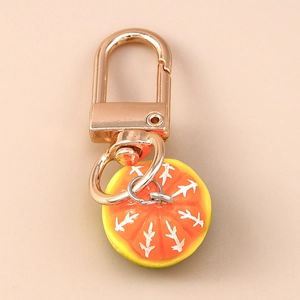 Macro view of detailed orange slice resin keychain with gold metallic D-ring buckle