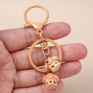 Close-up of realistic cupcake pendants on a lobster clasp keychain held in hand