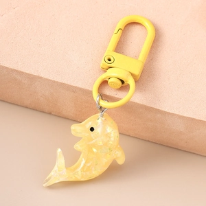 Vue macro d'un porte-clés dauphin jaune en résine scintillante avec fermoir