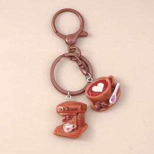 Close-up of creative coffee machine and latte art charms on a brown metal keychain