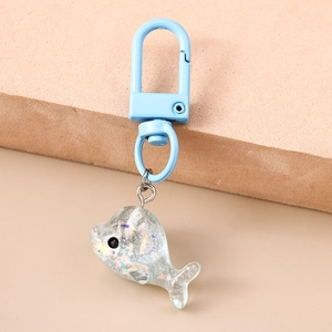 Détail d'un porte-clés baleine en résine à paillettes avec crochet bleu métallisé
