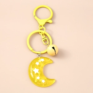 Detailed view of yellow resin moon keychain with embedded stars and a small bell