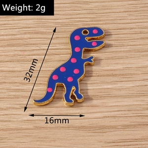 Macro shot of blue dinosaur enamel pendant showing 32mm height and 16mm width measurements
