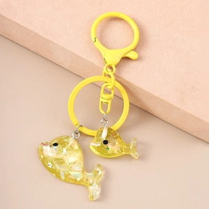 Dettaglio portachiavi a delfino giallo con paillettes e componenti metallici laccati