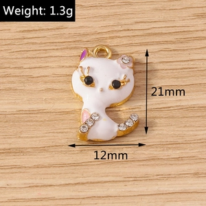 Detailed view of cat charm with white enamel and rhinestones showing 21mm by 12mm size