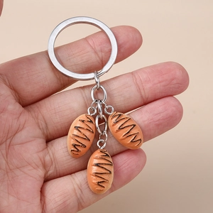 Detailed view of creative baguette bread charms on a silver metal keychain ring