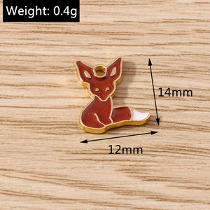 Detail of fox pendant charms in red enamel and gold metal for DIY jewelry making
