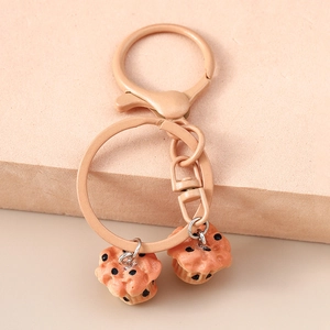 Close-up of dual muffin cupcake keychain with resin texture on a minimalist podium