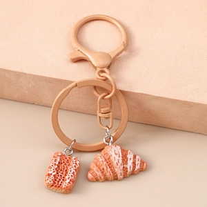 Detail of creative bread keychain with realistic resin croissant and toast pendants