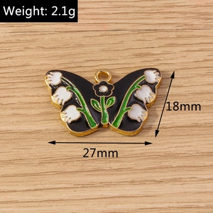 Detail of 27mm black enamel butterfly pendant with lily of the valley floral patterns