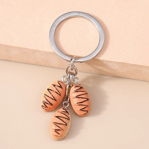 Close-up of creative mini baguette bread pendants with silver metal key ring and clip