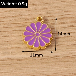 Vue macro d'un pendentif marguerite violette en finition dorée, 14mm x 11mm pour bijoux DIY