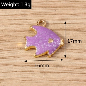 Detail view of a 17mm fish-shaped glitter charm with gold metal frame and purple sequins