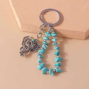 Ethnic style silver elephant keychain with turquoise stones and hollow floral design