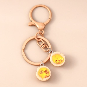 Detailed close-up of realistic resin fried egg keychain with a matching metal hook