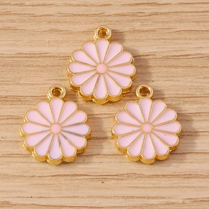 Pendentifs fleurs marguerites roses dorées pour bijoux DIY sur fond de bois