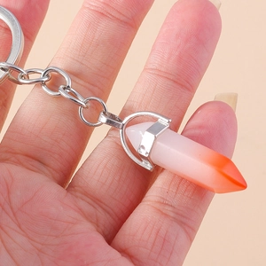 Close-up of a hexagonal crystal keychain with orange gradient stone and silver ring