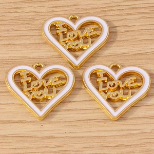 Three golden heart pendants with I Love You engraving on light wood background
