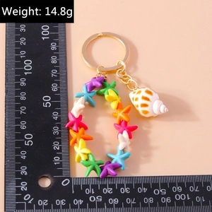 Detail of colorful star-shaped beads keychain with conch pendant and measurement ruler