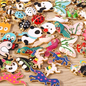 Detailed close-up of colorful enamel animal charms and pendants on wood background