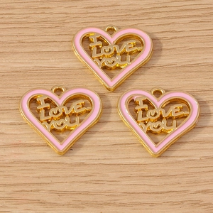 Close-up of heart-shaped I Love You pendants with pink enamel for DIY jewelry making