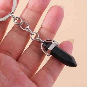 Detail of a minimalist black hexagonal stone pendant with a silver metallic keychain