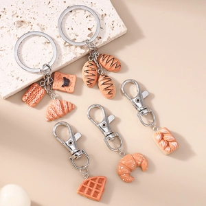 Realistic bread and croissant keychain set with silver metal ring on minimal background