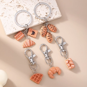 Macro shot of realistic croissant, waffle and baguette bread keychain charms set