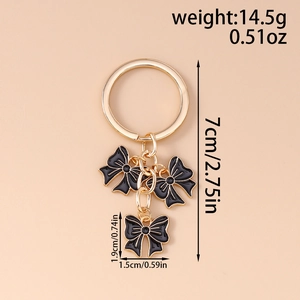 Detail showing dimensions of gold alloy bow keychain with black drip oil charms