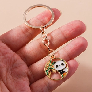 Detailaufnahme eines Panda- und Bambus-Emaille-Anhängers an einem goldenen Schlüsselring