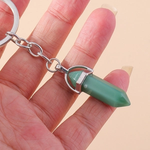 Detail view of a green aventurine hexagonal crystal pendant keychain held by hand