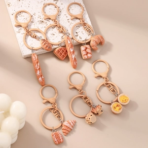 Cute realistic faux bread and pastry keychains arranged on a warm aesthetic background