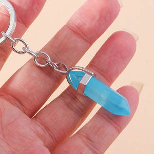Detail of a light blue hexagonal crystal pendant keychain with silver metal casing