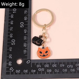 Macro view of Halloween keychain with weight scale showing black pumpkin and orange cat charm