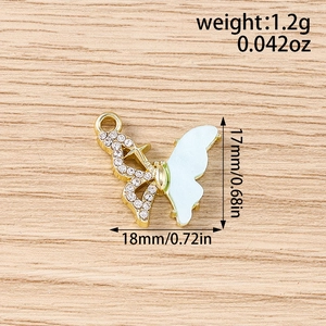 Détail macro du pendentif papillon en strass avec base dorée et dimensions précises