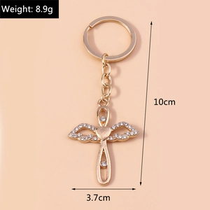 Detail view of golden christian cross keychain with angel wings and sparkling rhinestones