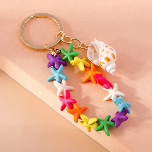 Detailed view of colorful resin starfish charms and a white seashell on a golden keychain