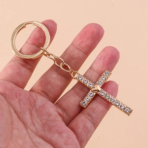 Gold-plated rhinestone cross keychain with heart center on a circular metal ring